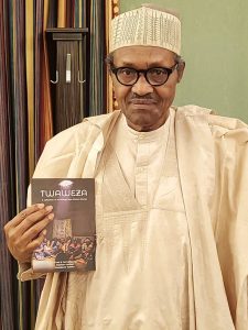 Nigerian President, Muhammadu Buhari, holding a copy of Twaweza